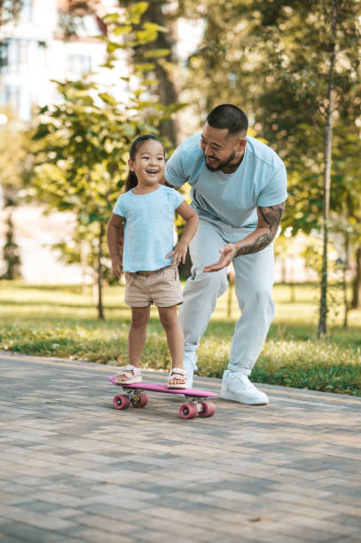 istock Dad teaching his daughter to ride a skate board 1446135286