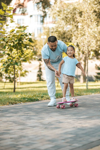 istock Dad teaching his daughter to ride a skate board 1446135325