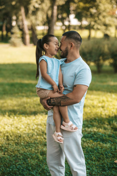 istock Young man holding his daughter while spending time in the park 1446135400