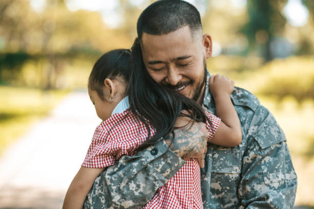 Service man hugging his little daughter and looking happy