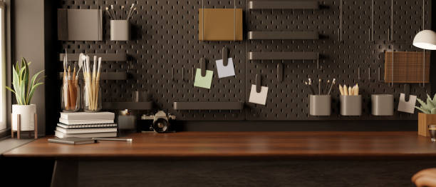 istock Modern black home office space with accessories and copy space on wood table against the black wall 1446140411