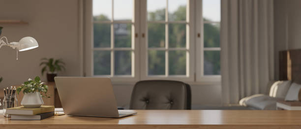 istock Comfortable and minimal working table in bedroom with laptop and copy space on wood table 1446140415
