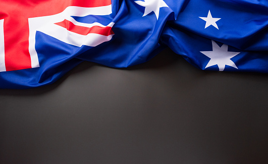 Happy Australia day concept. Australian flag against dark background. 26 January.