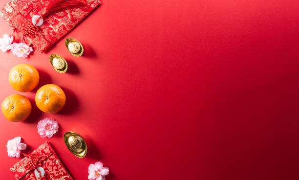 Chinese new year decorations made from red packet, orange and gold ingots or golden lump on a red background. Chinese characters FU in the article refer to fortune good luck, wealth, money flow. decoraciones de año nuevo chino hechas de paquetes rojos, lingotes naranjas y dorados o bultos dorados sobre un fondo rojo. los caracteres chinos fu en el artículo se refieren a la fortuna, la buena suerte, la riqueza, el flujo de dinero.