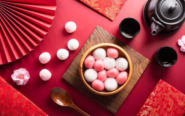 tang yuan(sweet dumplings balls), a traditional cuisine for mid-autumn, dongzhi (winter solstice ) and chinese new year with plum flower and tea on red background. - 元宵節 個照片及圖片檔