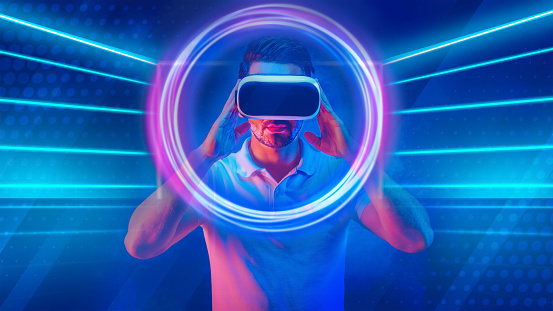 abstract virsual reality technology concept background of man wearing 3D goggle heatset overlay with neon light circle and lines in concept of cyberspace with virtual reality world