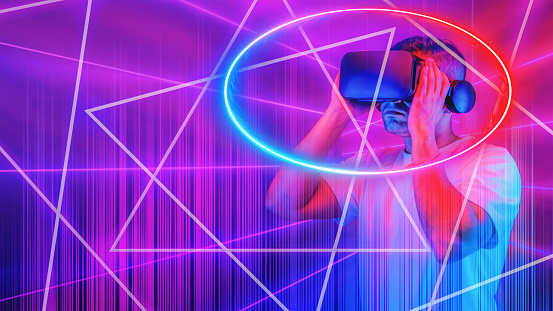 abstract virsual reality technology concept background of man wearing 3D goggle heatset overlay with neon light circle and lines in concept of cyberspace with virtual reality world