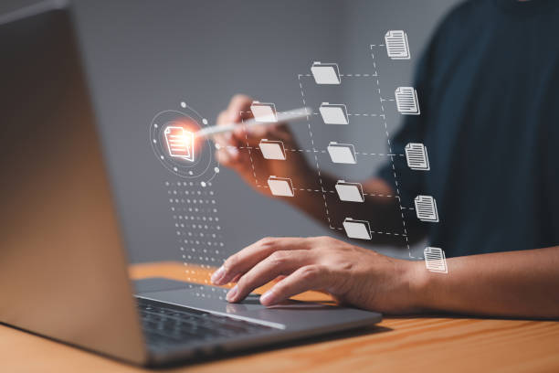 istock A businessman uses a computer to learn about document management concepts, online documentation databases, digital file storage systems, database technology, file access, and document sharing. 1446144512