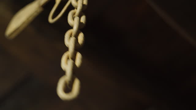 An old chain hanging from the ceiling in an old building.
