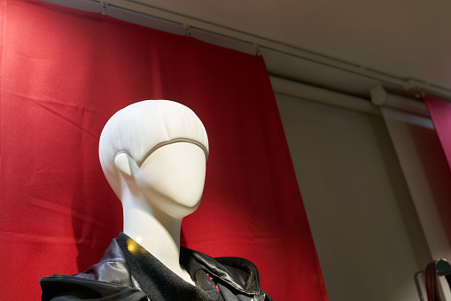 Head of a female mannequin against red background in a shop window in Colmar in France