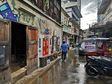 man walking on a flooded alley in Talad Noi, a historic neighbourhood in Bangkok. On the periphery of Bangkok's Chinatown, the area was Bangkok's first port, and was where immigrants landed. Thailand