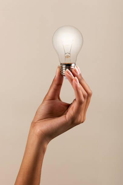 Crop female holding glowing light bulb stock photo