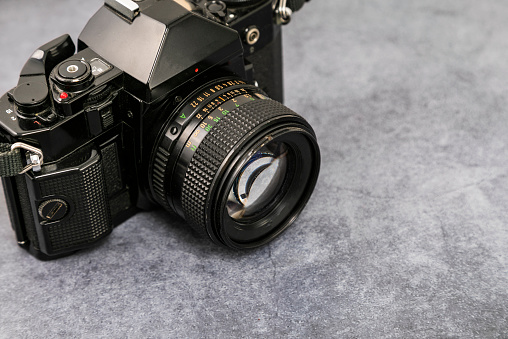 An old medium format camera with bellows lens from the 1940-50s on white background close up.