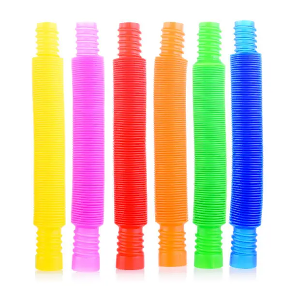 Photo of Pop tube isolated on a white background. A popular, sensory antistress toy. Corrugated tube for children. A new trend. Stress relief concept