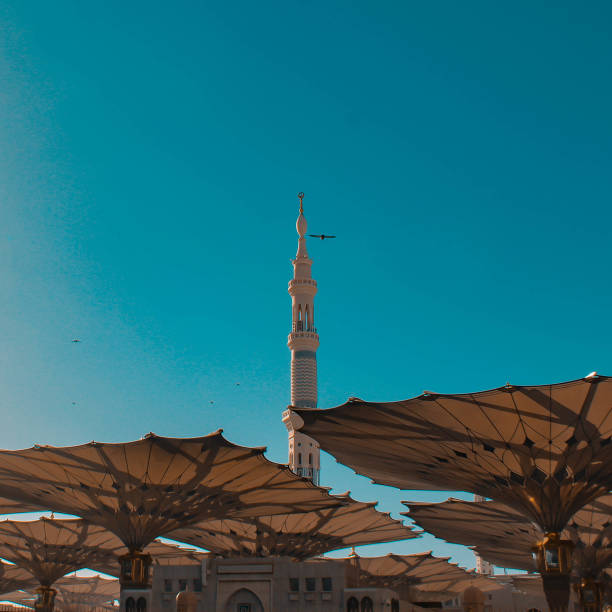 A picture of nabawi mosque tower in meddina with the umbrella opens