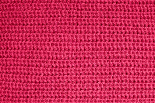Woolen knitted texture of vivid magenta color close-up