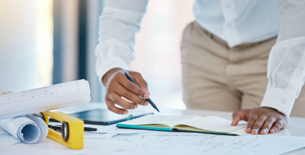 istock Architect, writing and planning with a business man drawing in a notebook with a blueprint and plan on a table in his office. Construction, engineer and architecture with a creative design at work 1446161314