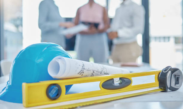 istock Construction, building design and architect blueprint of industrial engineer architecture project. Contractor, builder and buildings maintenance gear with spirit level and safety level for work team 1446161412