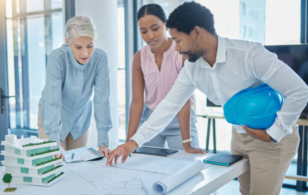 istock Design, construction and an architect in an office with blueprints, a city planning and strategy meeting. Architecture, engineering and apartment building plans, teamwork and  communication at work. 1446161413
