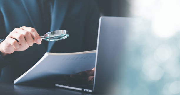 Businessman Audit documents with a magnifying glass, Quality Assessment Management with checklists, business document evaluation processes, market data report analysis and consulting