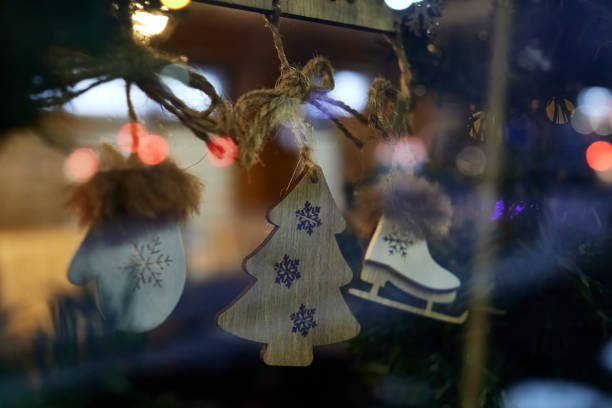 istock Christmas decorations stylized as a Christmas tree, mittens and skates, suspended by strings on the inscription bar, framed by fir branches. 1446166061