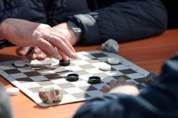 istock Outdoor draughts competition on paper checkerboard on table, close up players hands 1446168859