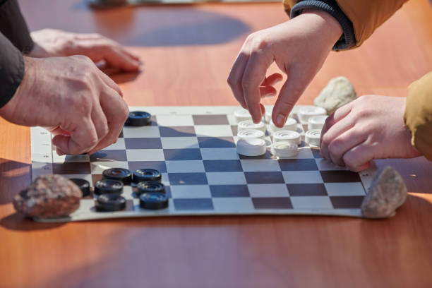 istock Outdoor draughts competition on paper checkerboard on table, close up players hands 1446168890