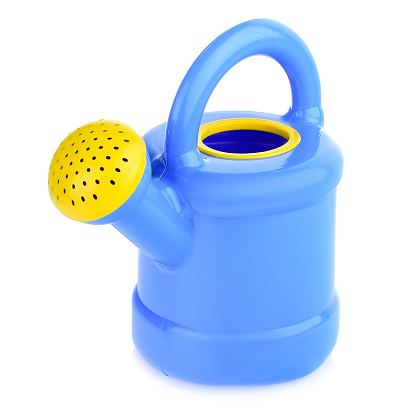 Children's plastic watering can for playing in the sandbox or in the garden. Color watering can for watering flowers, highlighted on a white background, close-up.