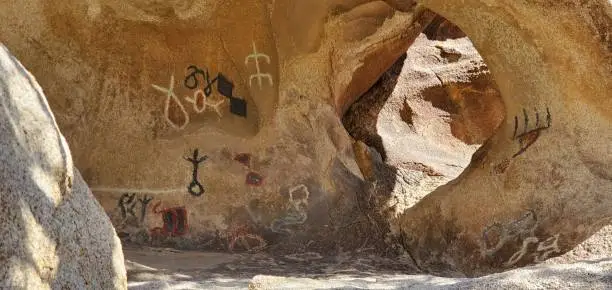 Photo of Cave with hieroglyphs and rock paintings in Joshua Tree. Hiking Barker Dam nature trail