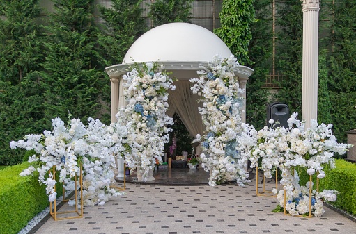 A front view of a beautiful wedding arch decorated with flowers
