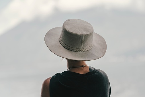 A back view of a stylish female in a boater hat by the Lake Atitlan, Guatemala
