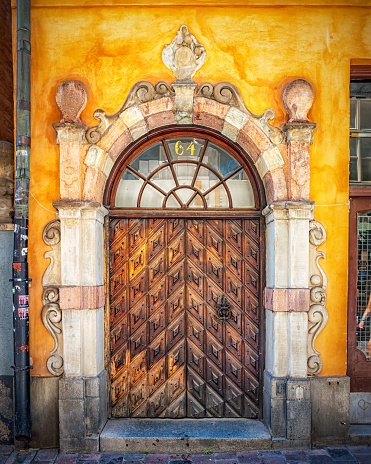 A vertical image of a beautiful ornate wooden door found in the Gamla stan area of Stockholm