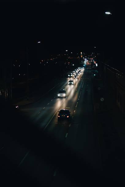 istock Aerial of traffic with bright light  reflection on a road at night, vertical 1446176785
