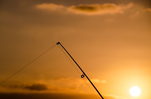 Fisherman Fishing Rod Silhouette at Orange Sunset
