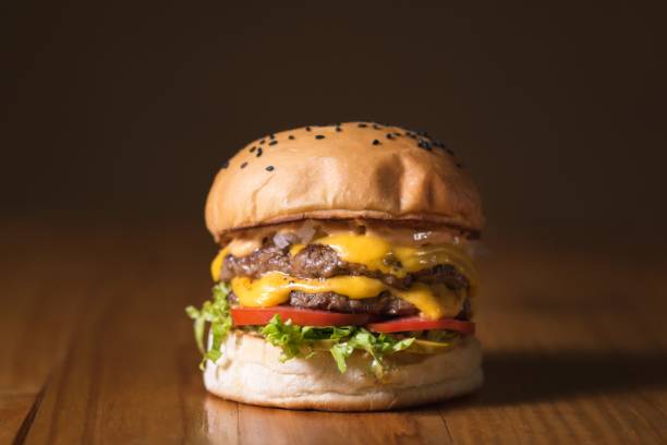 istock Appetizing double cheeseburger all ready and set on a wooden table 1446179882