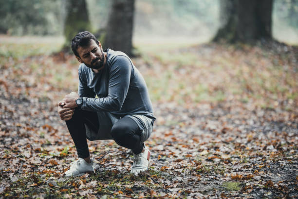 istock Athletic man feeling pain in his knee at the park. 1446185943