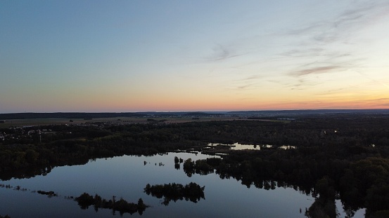 The trees reflected in the water at dawn