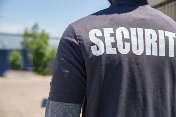 istock Security person standing outdoors in the sun, shot from back 1446188610