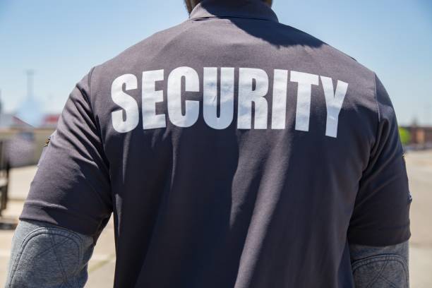 istock Security person standing outdoors in the sun, shot from back 1446188727