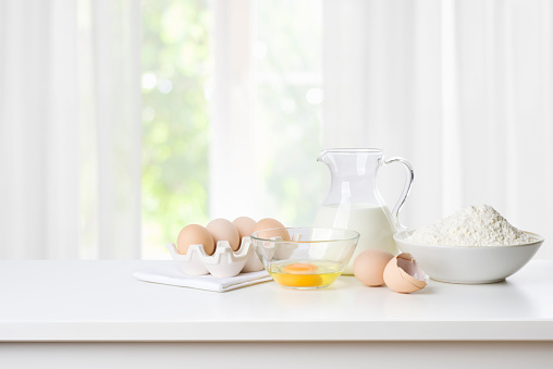 Baking concept with flour, eggs and milk on kitchen table