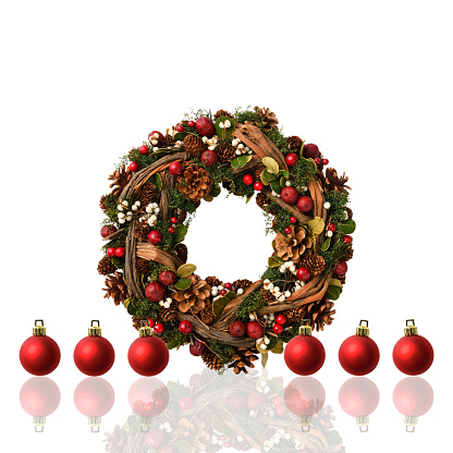 Winter and Christmas fir wreath composition with Jingle bells holly berries and pine cones isolated on white background with copy space