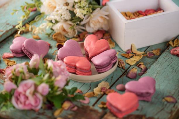 istock Heart shaped macarons on a wooden background, surrounded with flowers. 1446197953