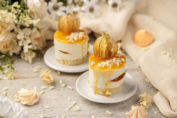 istock Mini peach cake on a white wooden background, surrounded with white roses. 1446198063