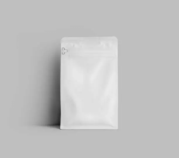 Mockup of a white doy pack for coffee beans, standing near the wall, the package is isolated on the background. Tea pouch template, stabilo pack gusset, for design, pattern, branding.