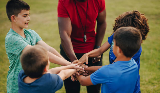 istock Coach and students putting their hands together in a huddle 1446209570