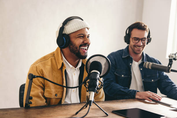 istock Happy radio presenter speaking into a microphone in a studio 1446209710