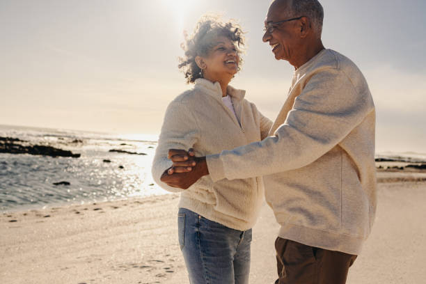 istock Cheerful senior couple dancing together at the beach 1446210557