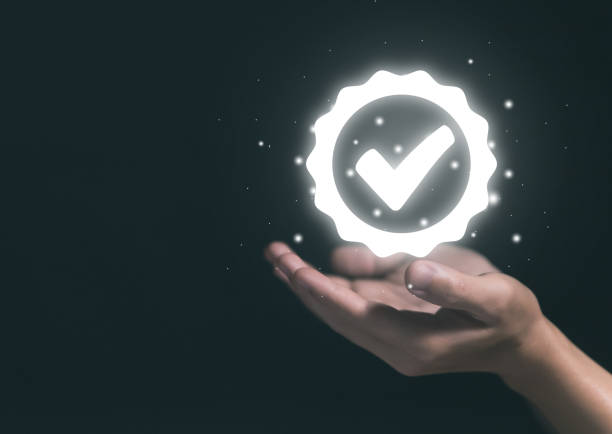 istock Hand showing a check mark. Guaranteed top quality. on a dark background 1446212083
