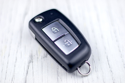 Human hand pushing button on remote control car key