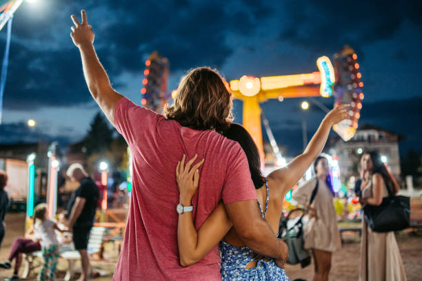 istock Young Couple Embracing In An Amusement Park 1446215444